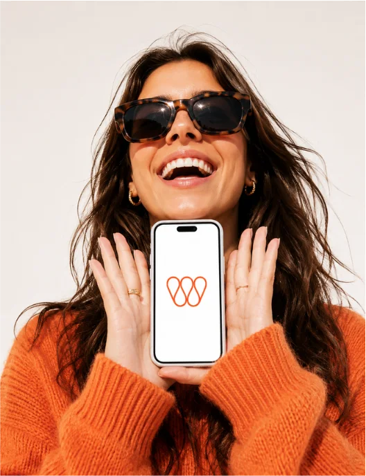 A guest smiling as she holds up a phone showing the Wheretogo app